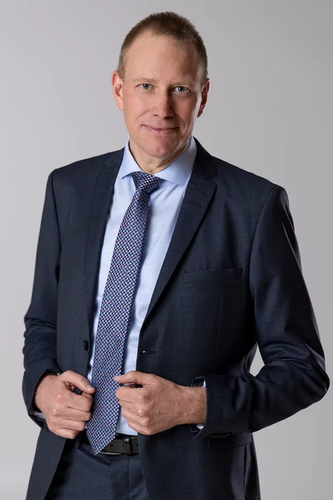 Professionelles Bewerbungsfoto eines Mannes im dunklen Anzug mit Krawatte vor neutralem Hintergrund, aufgenommen im Fotostudio Fokus.