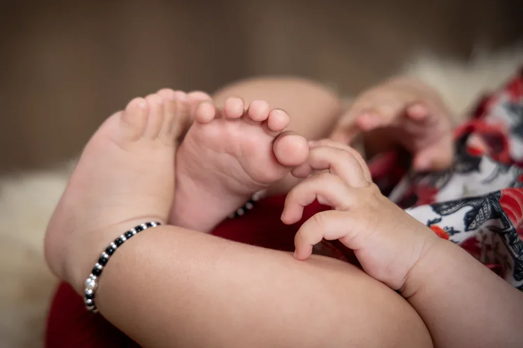 Liebevolle Detailaufnahme von Babyfüssen bei einem natürlichen Babyshooting mit warmer, ruhiger Bildstimmung