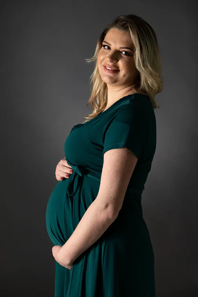 Natürliches Babybauch Portrait in Zofingen mit grünem Kleid, sanftem Licht und liebevollem Ausdruck
