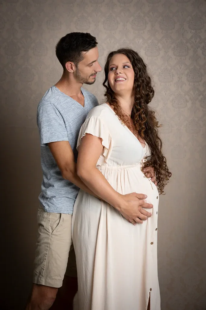 Liebevolles Babybauch Shooting in Zofingen mit Partner, hellem Kleid und warmer Studioatmosphäre