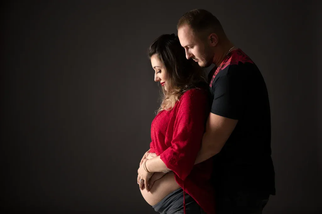 Emotionales Babybauch Shooting mit Partner in Zofingen, rotem Outfit und ruhiger Studioatmosphäre