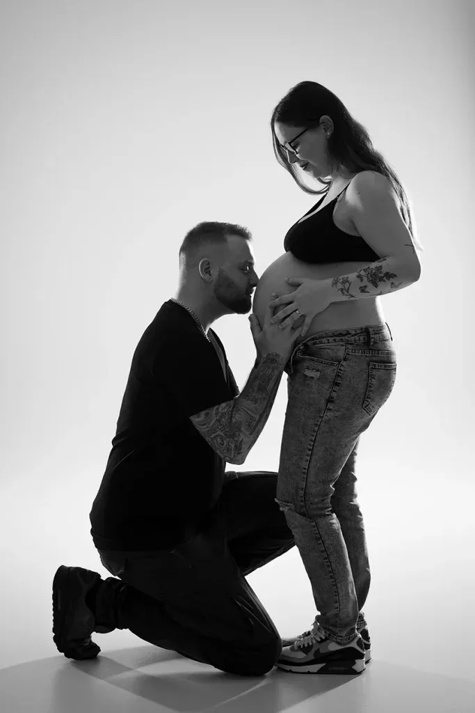 Emotionales Babybauch Shooting in Schwarzweiss mit Partner, liebevoller Berührung und ruhiger Studioatmosphäre