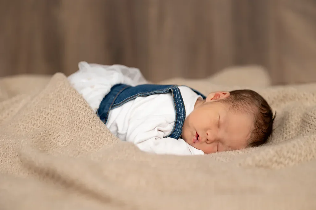 Natürliches Newborn Shooting in Zofingen mit schlafendem Baby auf weicher Decke und warmer Studioatmosphäre