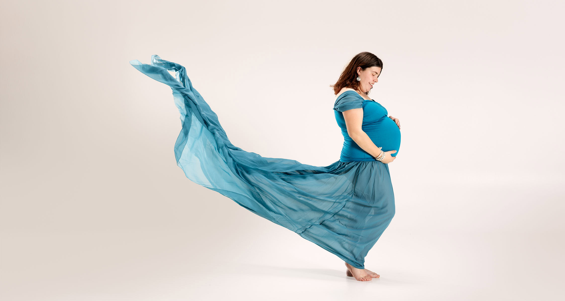 Babybauch Shooting in Zofingen mit blauem Kleid, fliessendem Stoff und natürlicher Studioatmosphäre