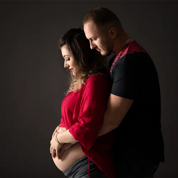 Emotionales Babybauch Shooting mit Partner in Zofingen, rotem Outfit und ruhiger Studioatmosphäre