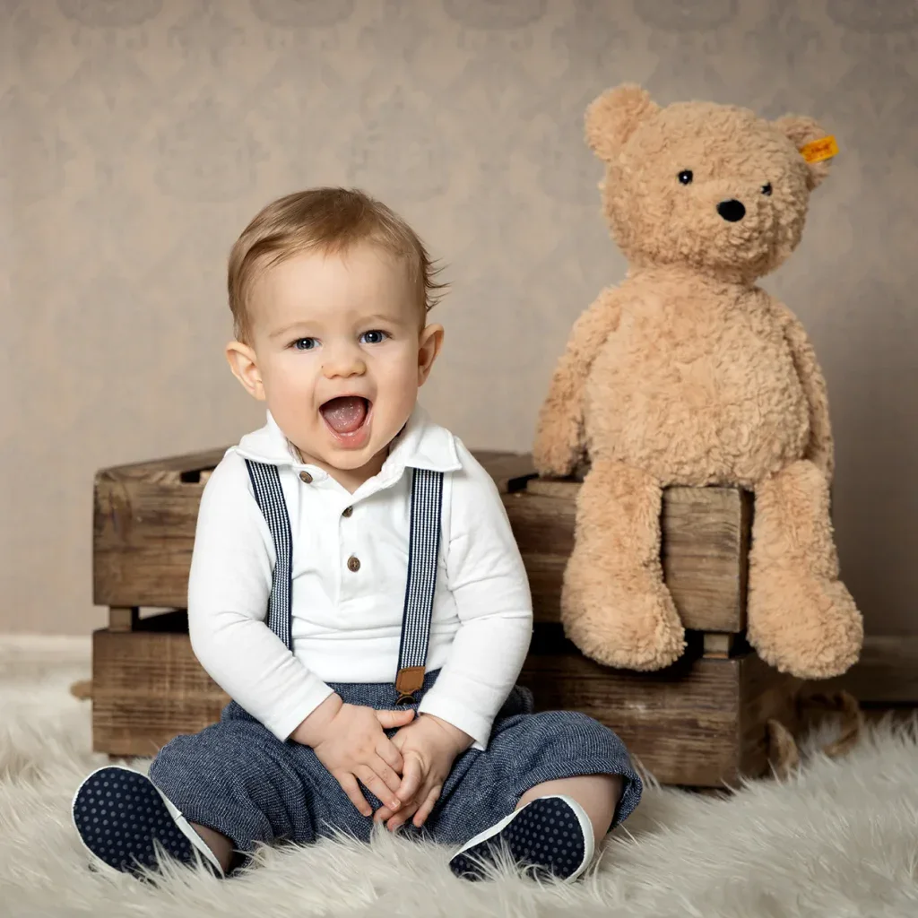 Liebevolles Babyfoto in Zofingen mit Baby und Teddybär, warmem Licht und gemütlicher Studioatmosphäre
