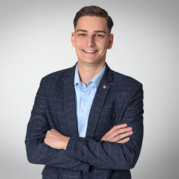 Professionelles Porträt eines jungen Mannes im Blazer mit verschränkten Armen