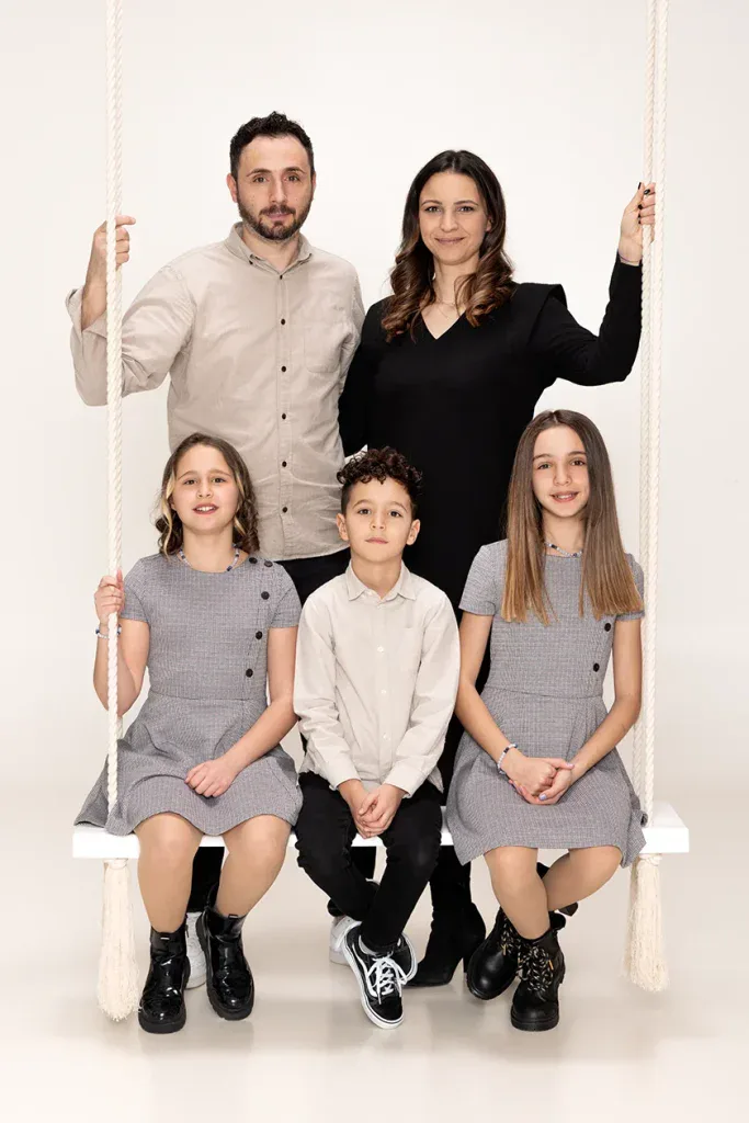 Natürliches Familienportrait in Zofingen mit Eltern und drei Kindern, warmem Hintergrund und ruhiger Studioatmosphäre
