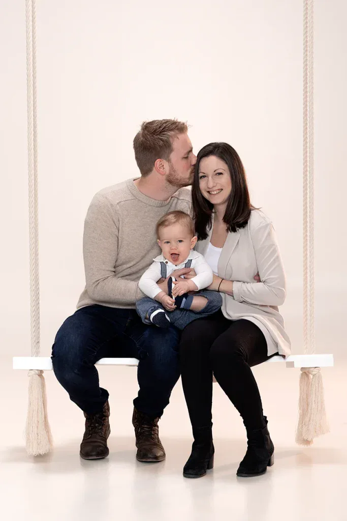 Natürliches Familienfoto in Zofingen mit Eltern und Kleinkind auf Schaukel, liebevoll und ungezwungen fotografiert
