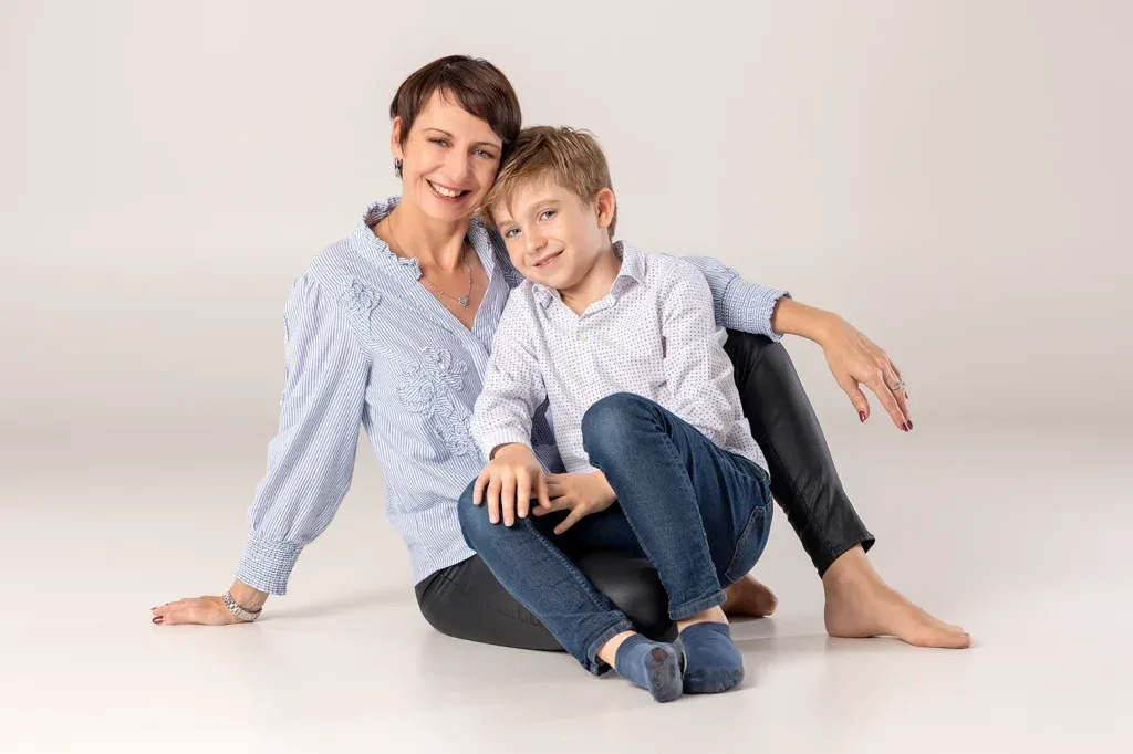 Liebevolles Familienfoto in Zofingen mit Mutter und Sohn sitzend im Fotostudio vor hellem Hintergrund