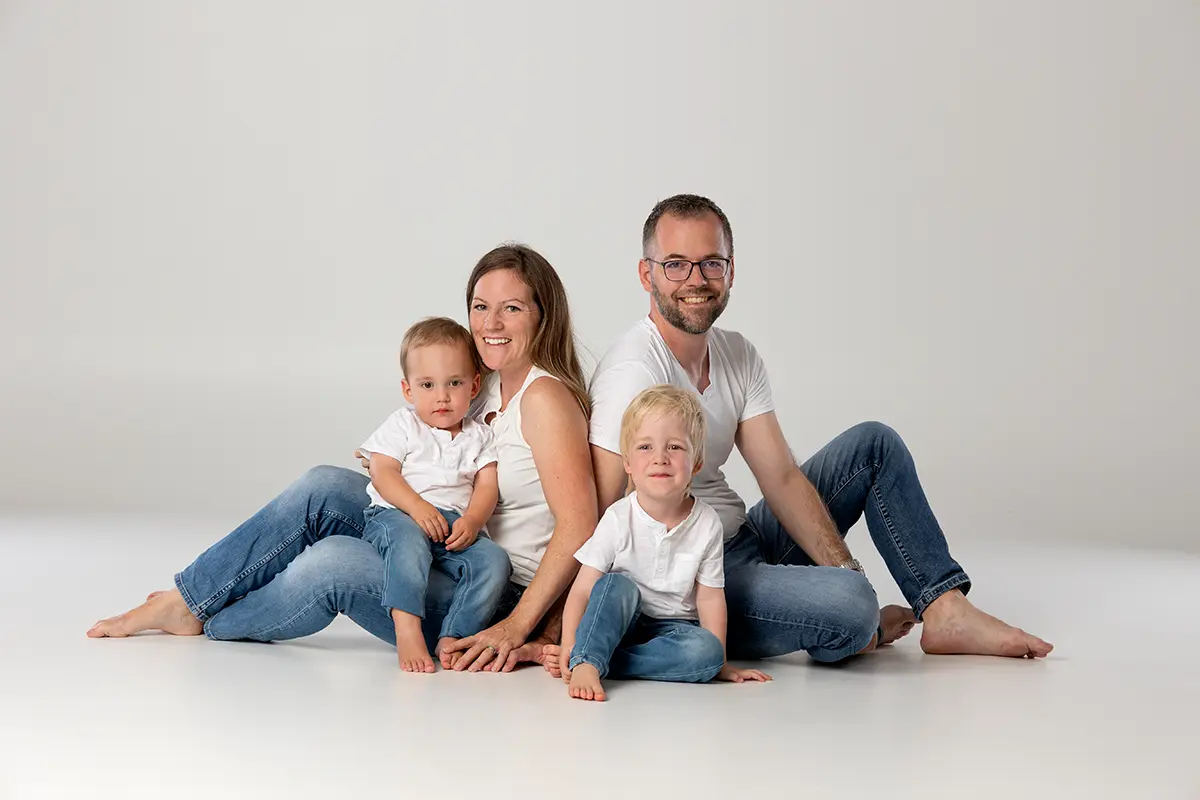 Natürliches Familienfoto in Zofingen mit Eltern und zwei Kindern im Fotostudio Fokus, hell und liebevoll fotografiert