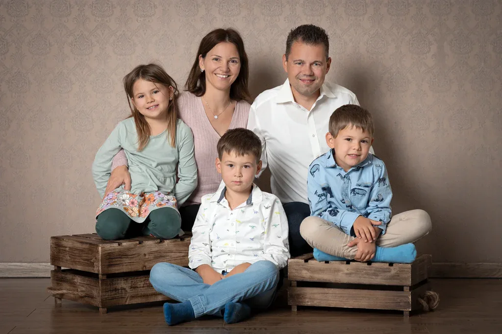 Natürliches Familienportrait in Zofingen mit Eltern und drei Kindern, warmem Hintergrund und ruhiger Studioatmosphäre
