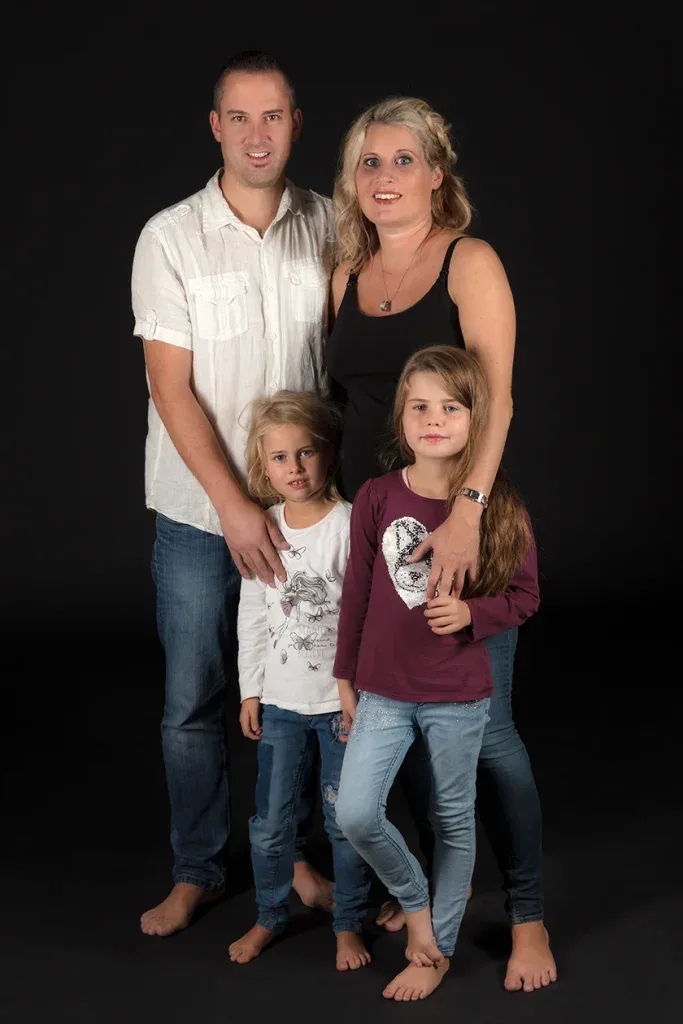 Klassisches Familienportrait in Zofingen mit Eltern und zwei Kindern vor dunklem Hintergrund