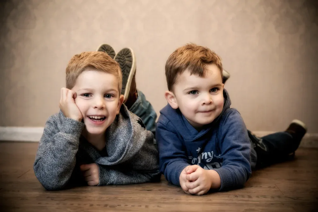 Natürliches Geschwisterfoto in Zofingen mit zwei Jungen auf dem Boden, locker und lebendig fotografiert