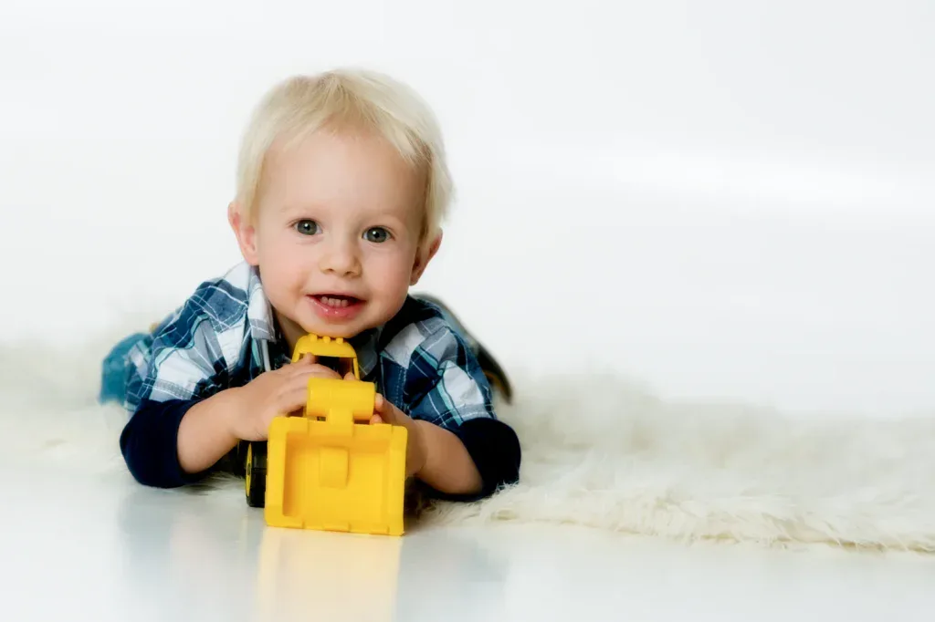 Natürliches Kinderportrait in Zofingen mit Kleinkind und gelbem Spielzeug, hell und freundlich fotografiert
