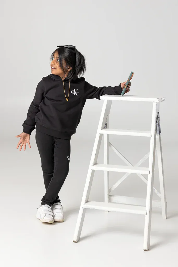 Natürliches Kindershooting in Zofingen mit Mädchen, Leiter und spielerischer Pose im hellen Fotostudio