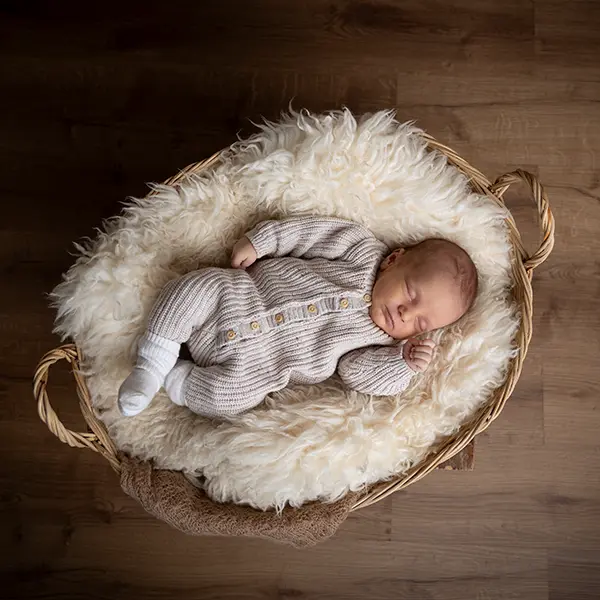 Natürliches Newborn Shooting in Zofingen mit schlafendem Baby im Korb, weicher Decke und warmer Bildstimmung