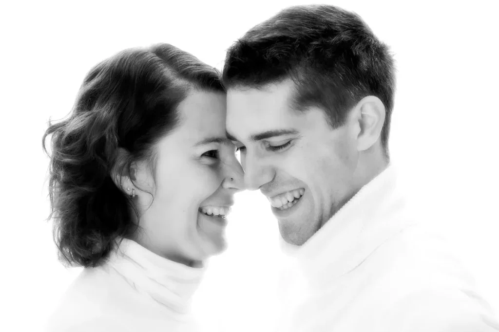 Nahes Paarportrait in Schwarzweiss mit natürlichem Lachen, Nähe und heller Bildstimmung