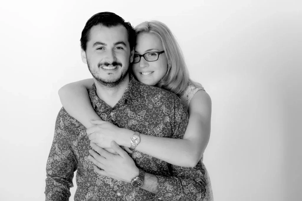 Schwarzweiss-Paarportrait mit Umarmung, natürlicher Nähe und ruhiger Studioaufnahme