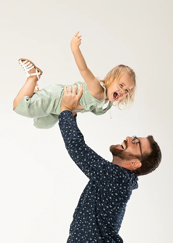 Lebendiges Familienfoto in Zofingen mit Vater und Tochter beim Spielen, voller Freude und Bewegung