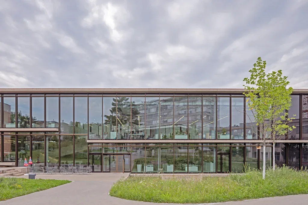 Moderne Glasfassade des Balgrist Campus in Zürich mit Spiegelungen und klarer Gebäudestruktur.