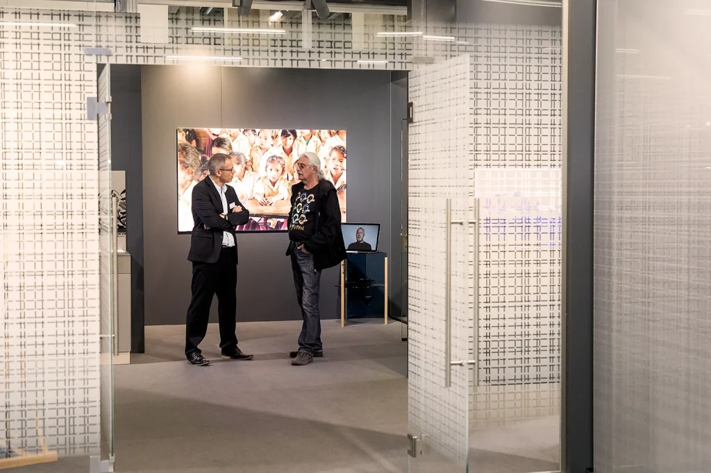 Zwei Teilnehmer unterhalten sich in einem modern gestalteten Ausstellungsraum.