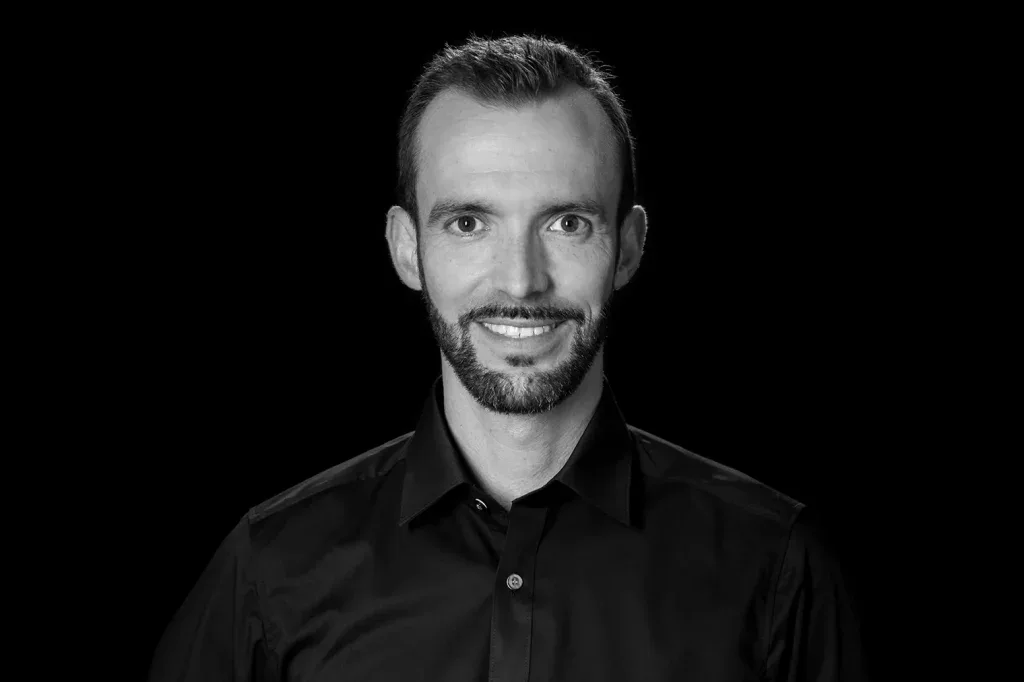 Charakterstarkes Businessportrait eines Architekten vor dunklem Hintergrund für Corporate Design und Teamseite.