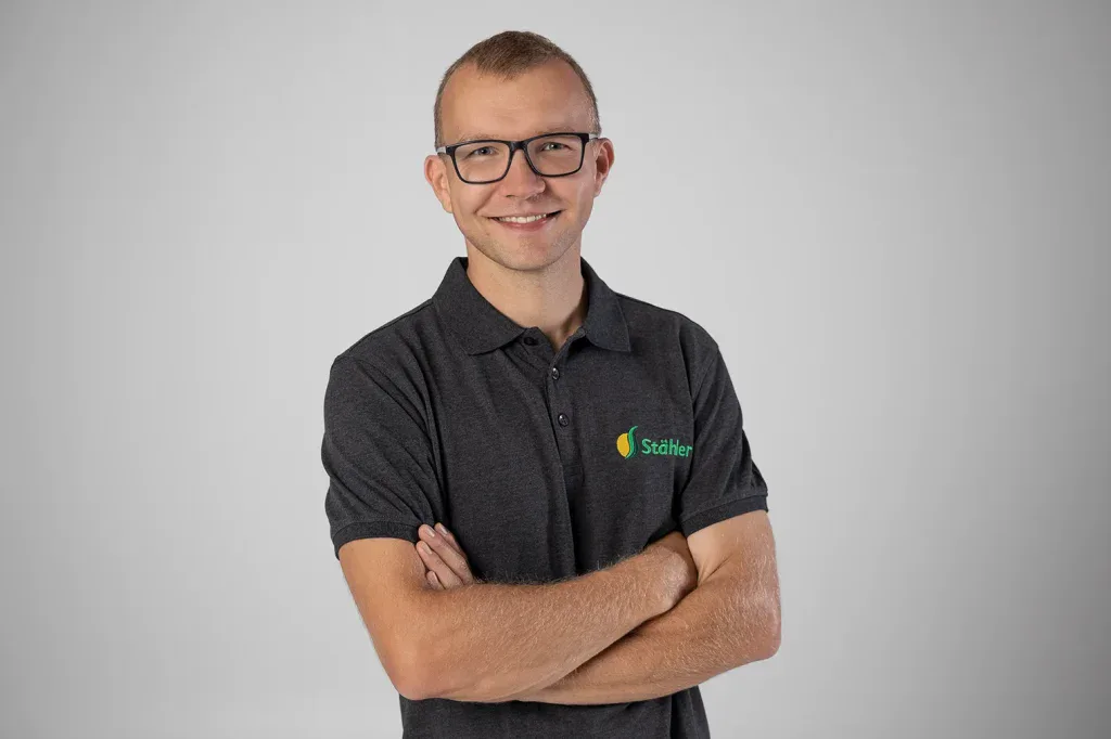 Professionelles Mitarbeiterportrait vor grauem Hintergrund für Firmenfotografie, Teamseite und Employer Branding.