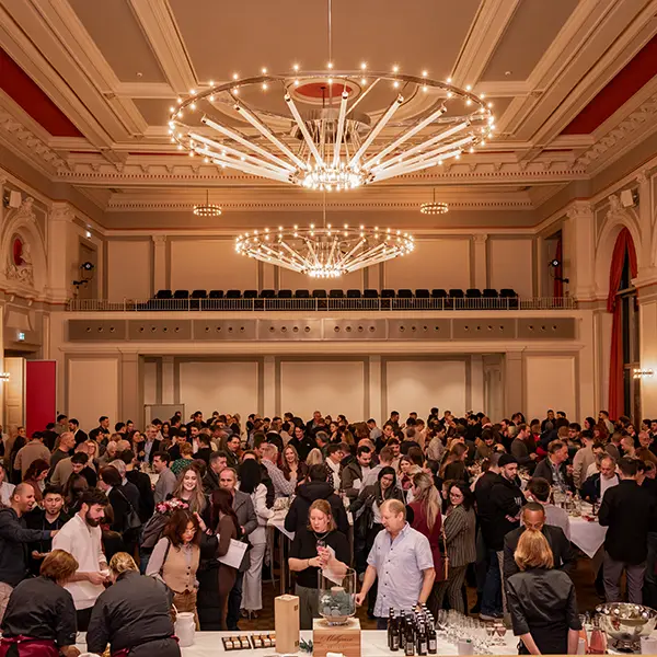Grosses Publikum verfolgt aufmerksam einen Fachvortrag an einer Firmenveranstaltung. Professionelle Eventfotografie für Konferenzen und Business-Events.