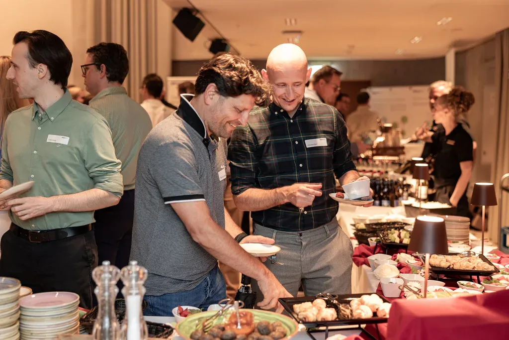 Gäste bedienen sich an einem vielseitigen Buffet während eines Firmenanlasses.