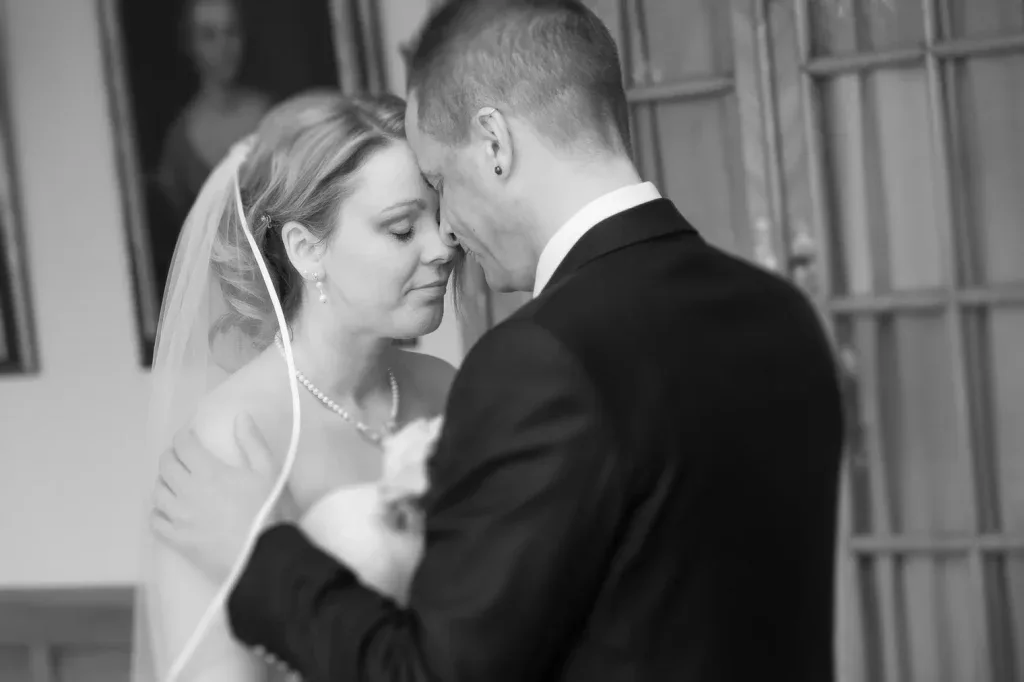 Brautpaar in einem innigen Moment während der Hochzeit in Schwarz-Weiss.