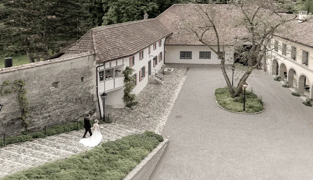 Brautpaar unterwegs in einem historischen Schlosshof während einer Hochzeitsreportage.