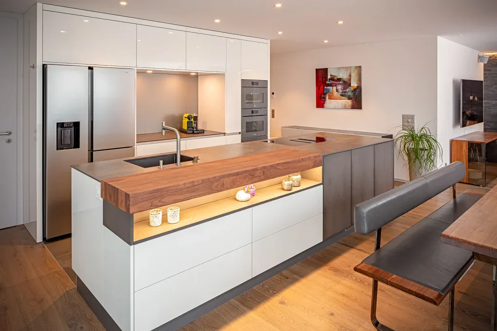 Offene Küche mit Holzelementen, heller Theke und angrenzendem Essbereich in einer Wohnung.