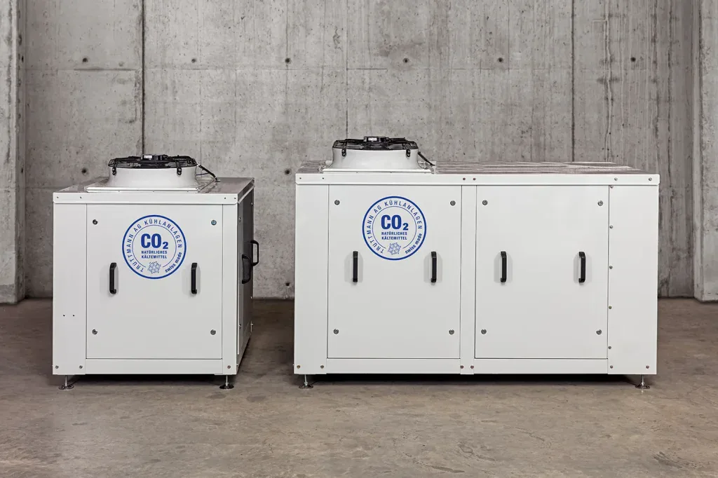 Zwei technische CO2-Anlagen vor Sichtbetonwand als sachliche industrielle Produktfotografie.
