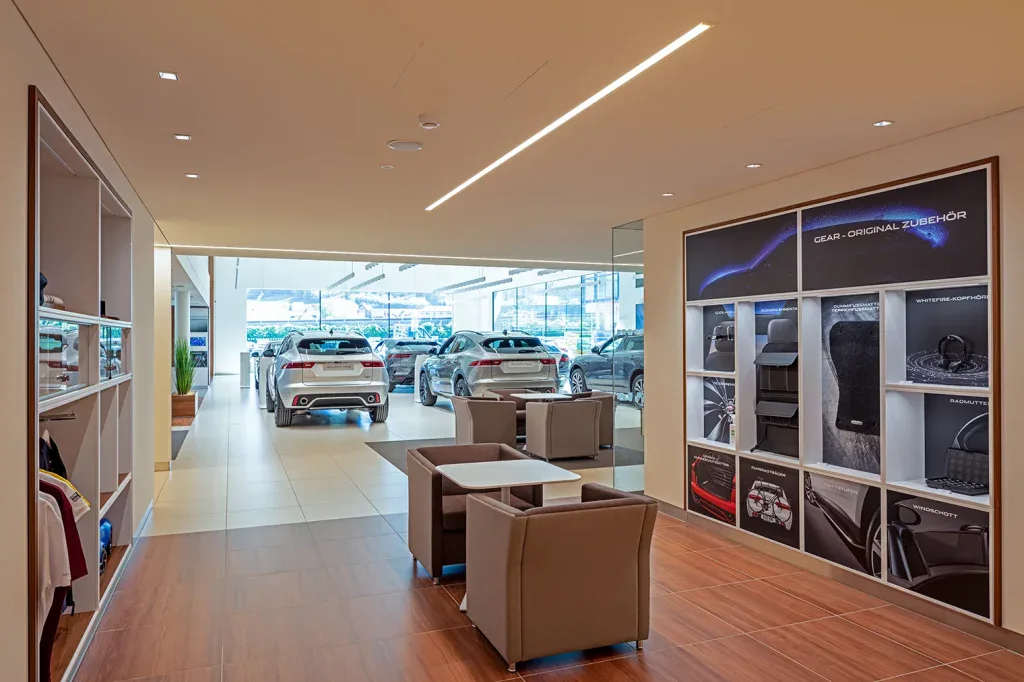 Moderner Showroom mit Lounge, Produktpräsentation und linearen Deckenleuchten in Safenwil.