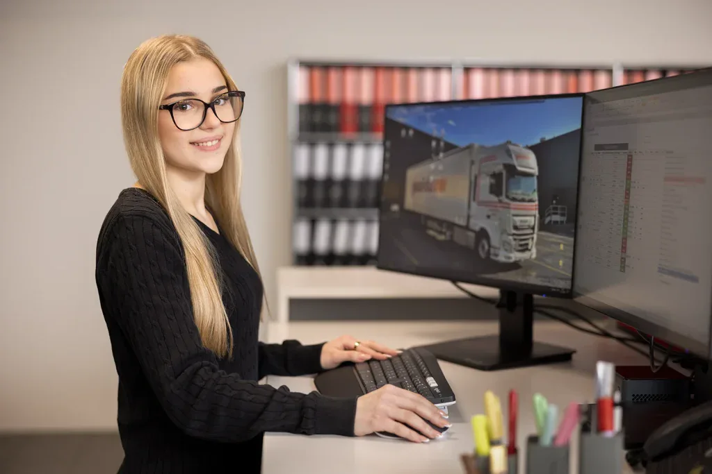 Mitarbeiterin arbeitet am Computer an einer Fahrzeugdarstellung in einem modernen Büro.