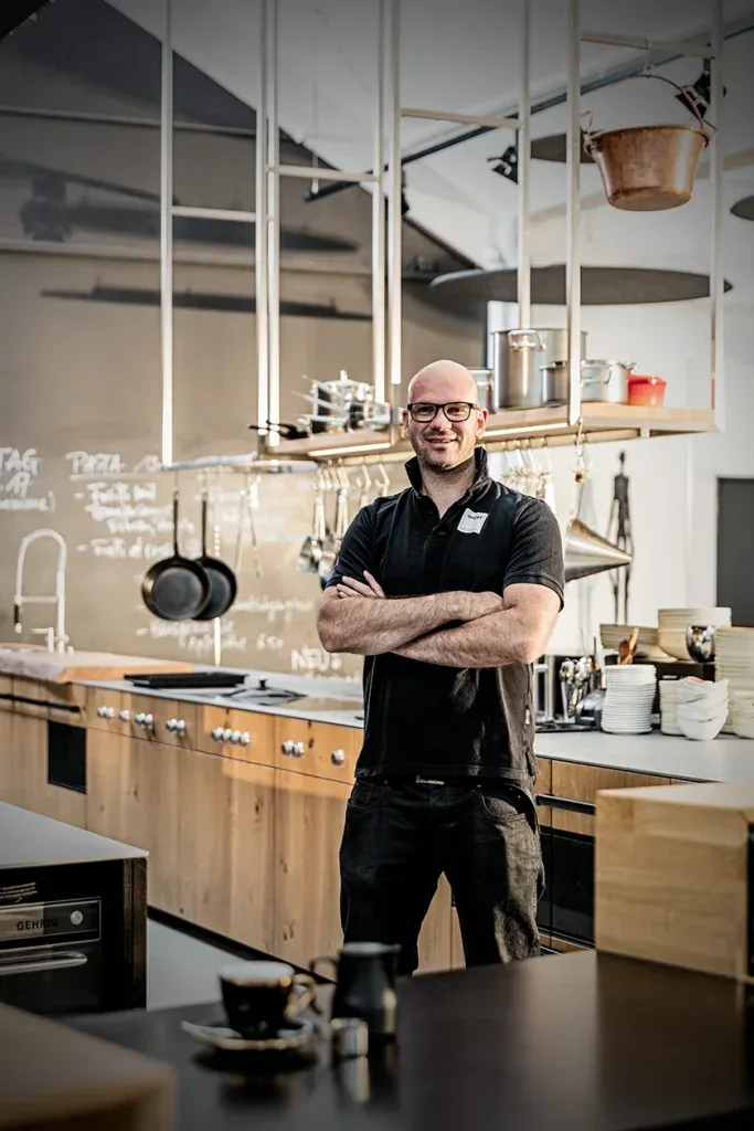 Mitarbeiterportrait eines Mitarbeiters in einer modernen Küche, ideal für Gastronomie, Teamvorstellung und Firmenwebsite.