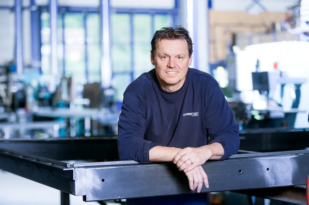 Mitarbeiterportrait eines Mannes in einer Produktionshalle, aufgenommen für Unternehmensfotografie und Employer Branding.