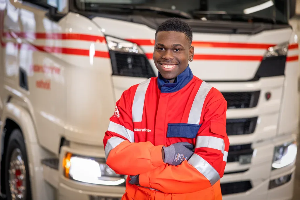 Mitarbeiterportrait eines Logistikmitarbeiters vor einem Lastwagen für Unternehmensfotografie und Recruiting.