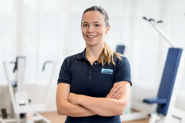 Natürliches Mitarbeiterportrait einer Physiotherapeutin in einer hellen Praxis