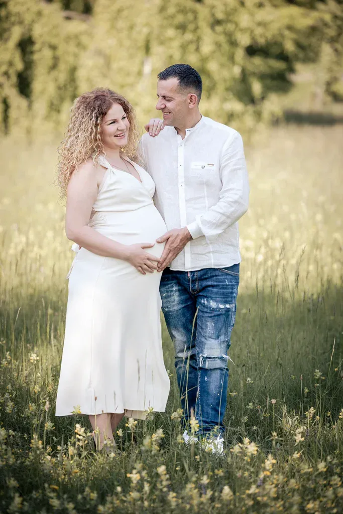 Werdende Eltern bei einem natürlichen Babybauchshooting draussen auf einer Wiese in der Umgebung von Zofingen.