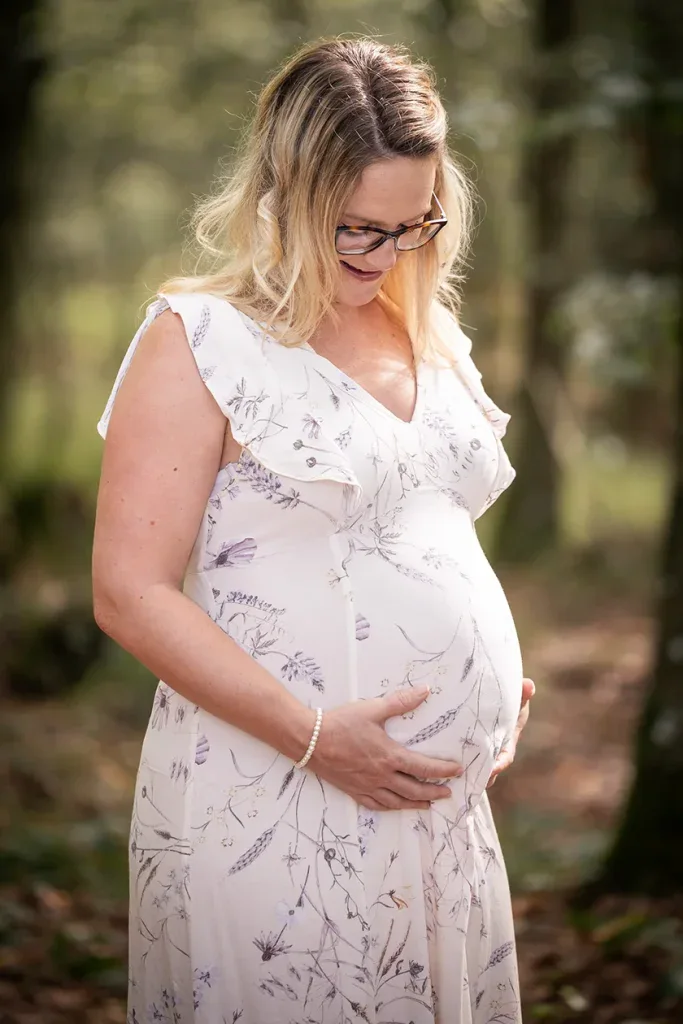 Schwangere Frau bei einem natürlichen Outdoor-Babybauchshooting im Wald.
