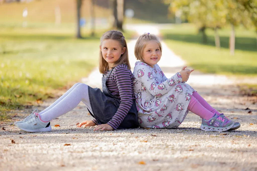 Zwei Kinder bei einem natürlichen Outdoor-Fotoshooting im Grünen.