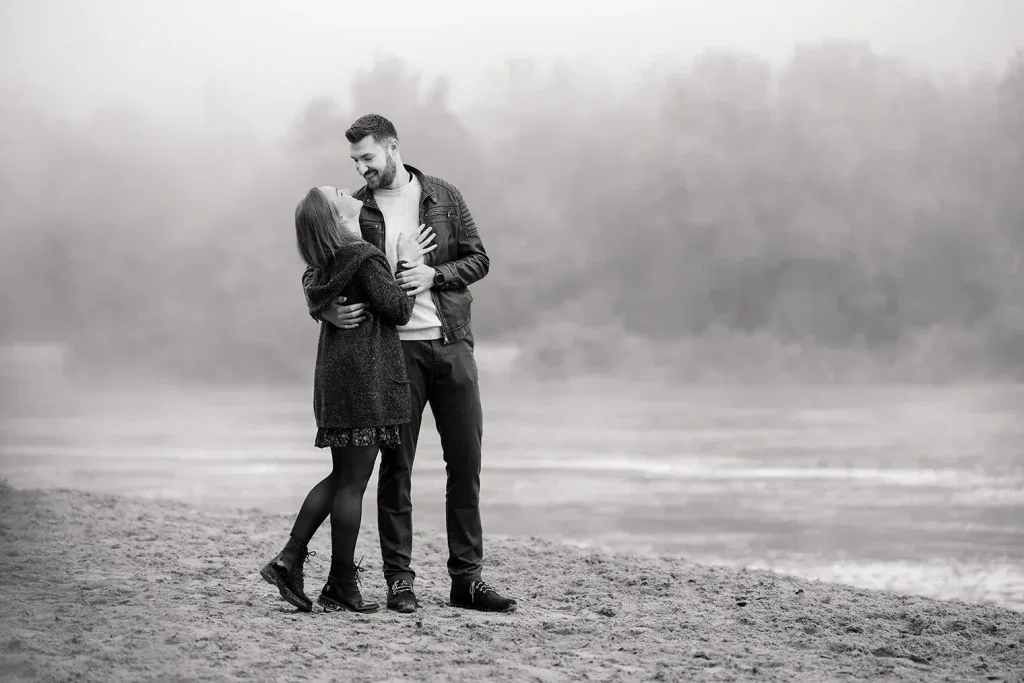 Paar bei einem emotionalen Outdoor-Fotoshooting in Schwarz-Weiss am Wasser.