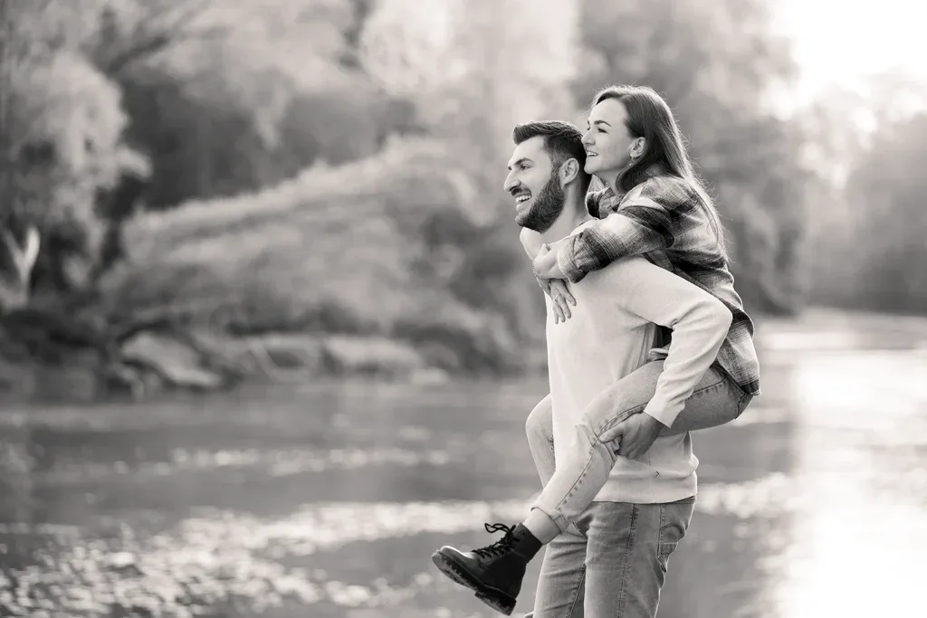 Paar bei einem lebendigen Outdoor-Fotoshooting in Schwarz-Weiss am Wasser.