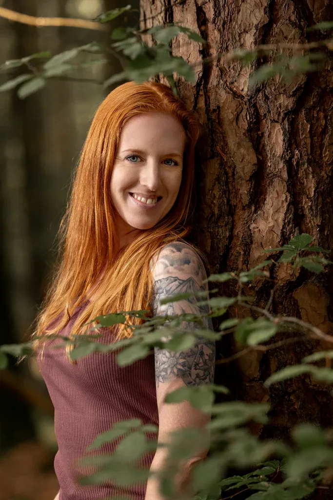 Frau bei einem natürlichen Outdoor-Portraitshooting im Wald mit weichem Licht.