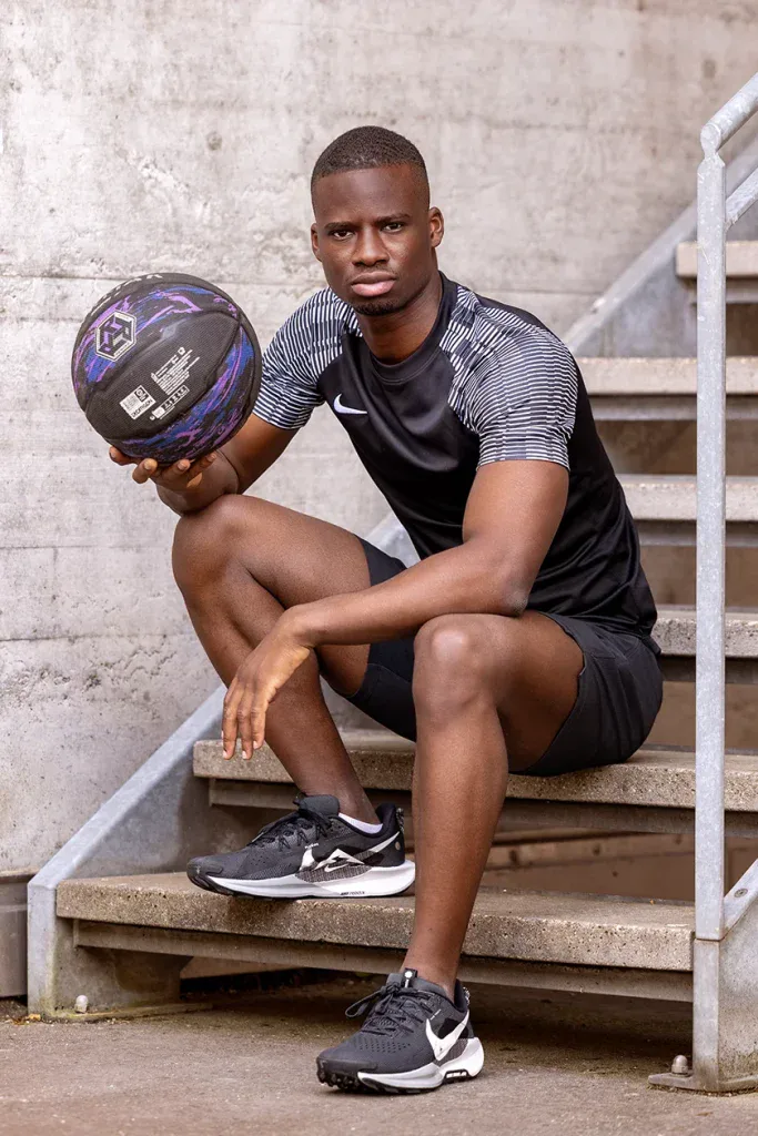 Sportler mit Basketball bei einem Outdoor-Portraitshooting an einer urbanen Location.