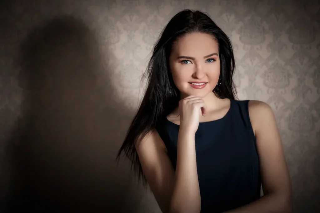 Klassisches Portraitshooting in Zofingen mit Frau vor strukturierter Studiokulisse und weichem Licht.