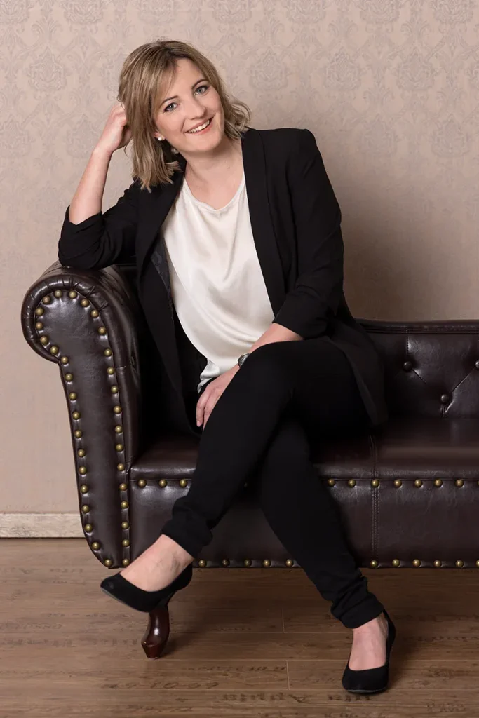 Klassisches Portraitshooting in Zofingen mit Frau auf Ledersessel vor eleganter Studiokulisse.