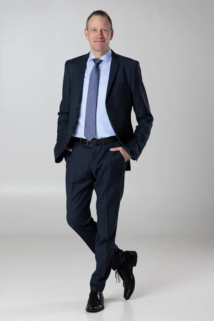 Professionelles Businessportrait in Zofingen mit Mann im Anzug als Ganzkörperaufnahme vor hellem Hintergrund.